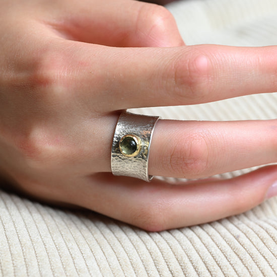 13 mm breiter Bicolor-Ring aus Silber und Gold mit grünem Peridot, getragen an einer Hand.