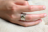 13 mm breiter Bicolor-Ring aus Silber und Gold mit grünem Peridot, getragen an einer Hand.