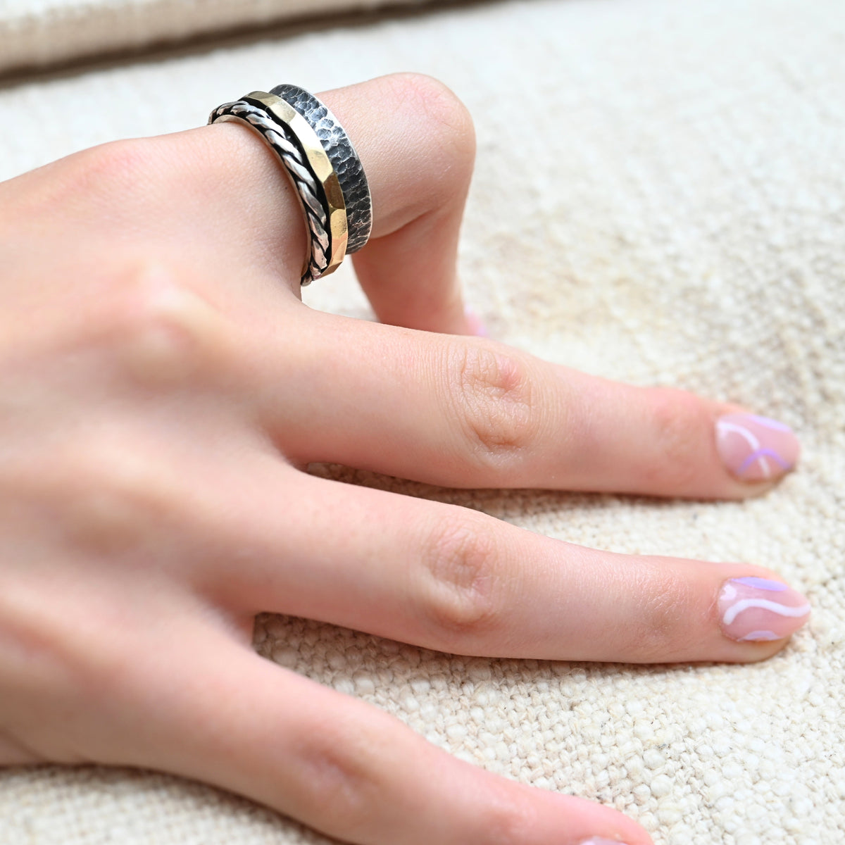 Bicolorring Idit mit gehämmertem Goldband und gezwirbelter Silberkante in der Ansicht am Finger